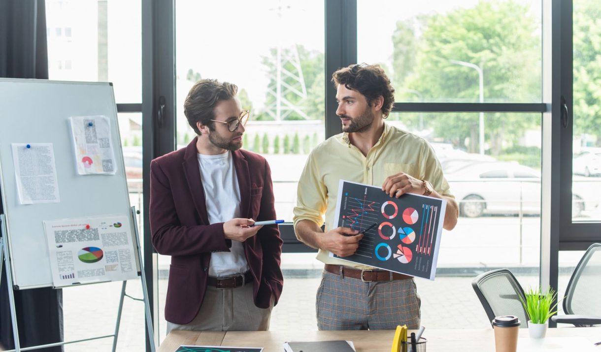 businessmen pointing at document with charts while fysv8ey