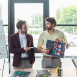 businessmen pointing at document with charts while fysv8ey